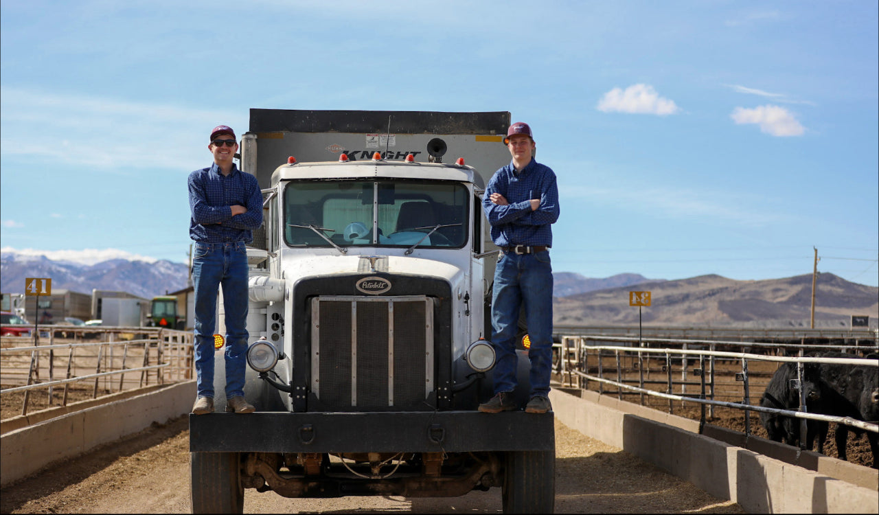 Two Uthmanns standing on a large truck at the ranch